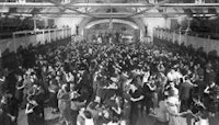 a crowd of people dancing in a large hall